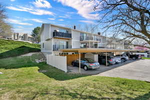 Back of property featuring a balcony, covered parking, and a chimney