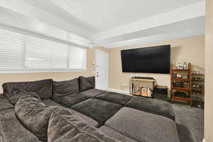 Carpeted living area featuring a textured ceiling and baseboards
