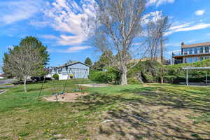 View of grassy yard featuring a playground