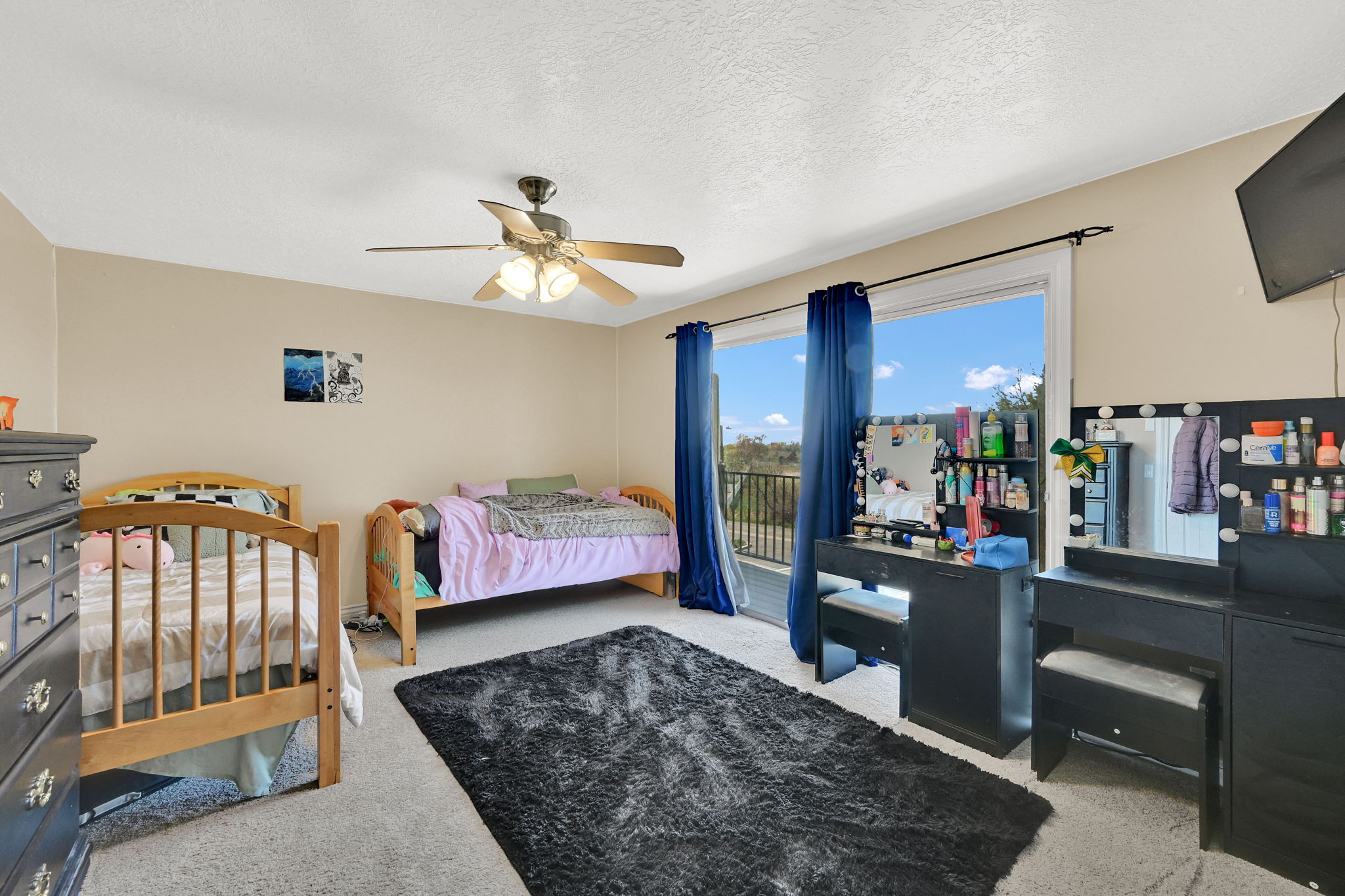 Bedroom featuring light carpet, access to outside, ceiling fan, and a textured ceiling