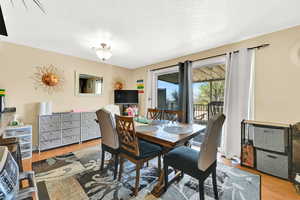Dining space with light wood-style flooring and a textured ceiling