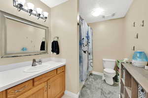 Full bathroom featuring vanity, a shower with curtain, and a textured ceiling