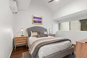 Bedroom with vaulted ceiling, wood finished floors, and a ceiling fan