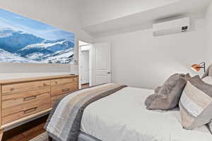 Bedroom featuring a mountain view, a wall mounted mini split, and dark wood-type flooring