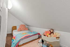 Bedroom featuring wood finished floors and baseboards