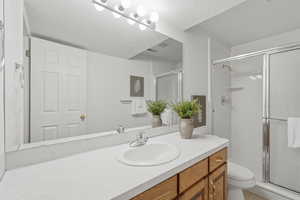 Full bath featuring a stall shower and vanity