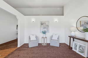 Sitting room featuring carpet flooring and arched walkways