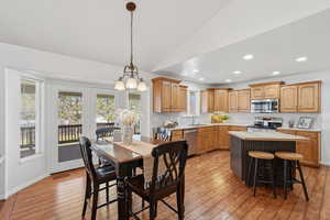 Dining space with light wood-type flooring, vaulted ceiling, and recessed lighting