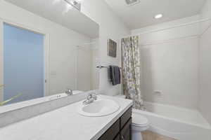 Full bath with vanity, shower / tub combo with curtain, and recessed lighting