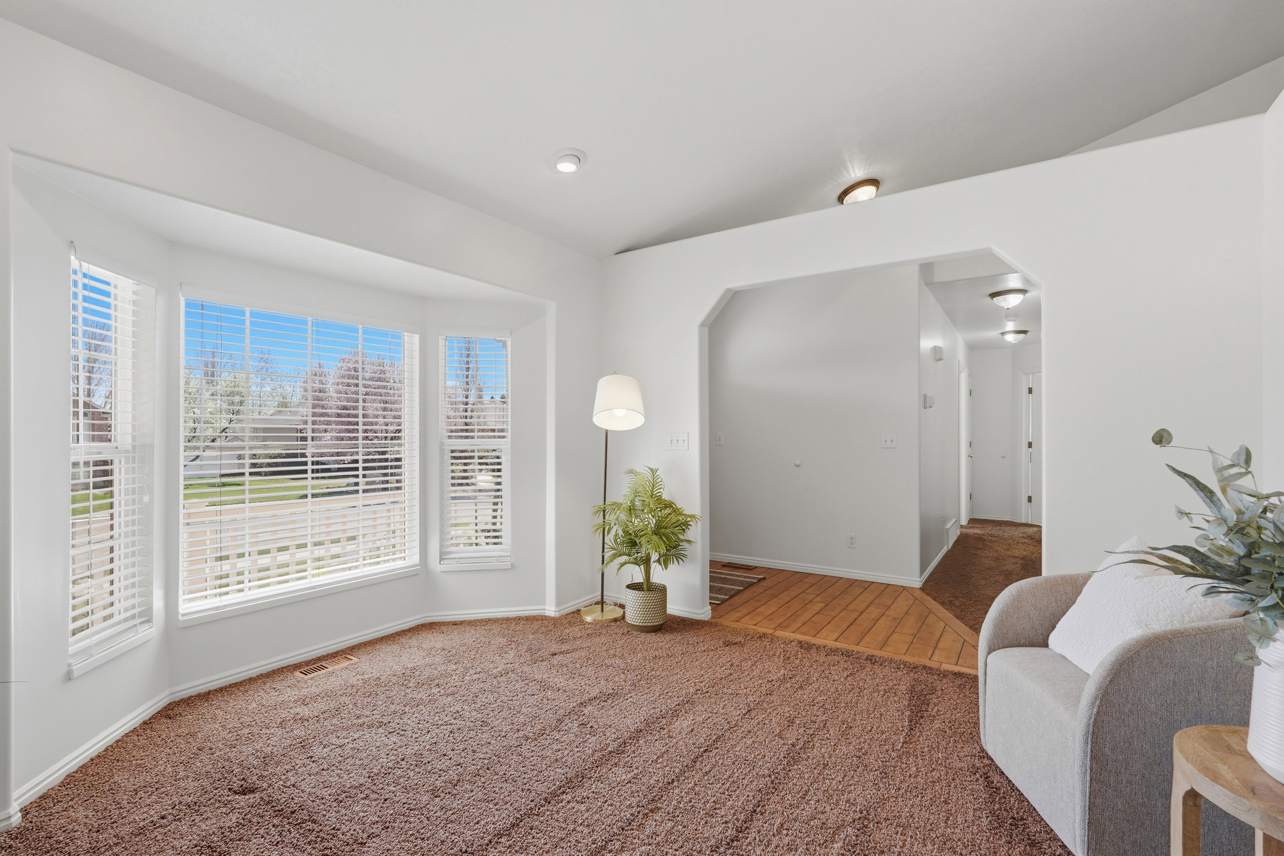 Sitting room featuring arched walkways, carpet, and lofted ceiling