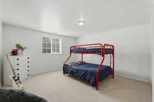 Bedroom with baseboards and light carpet