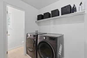 Laundry room with separate washer and dryer and baseboards