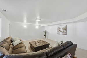 Living area featuring light colored carpet and a textured ceiling