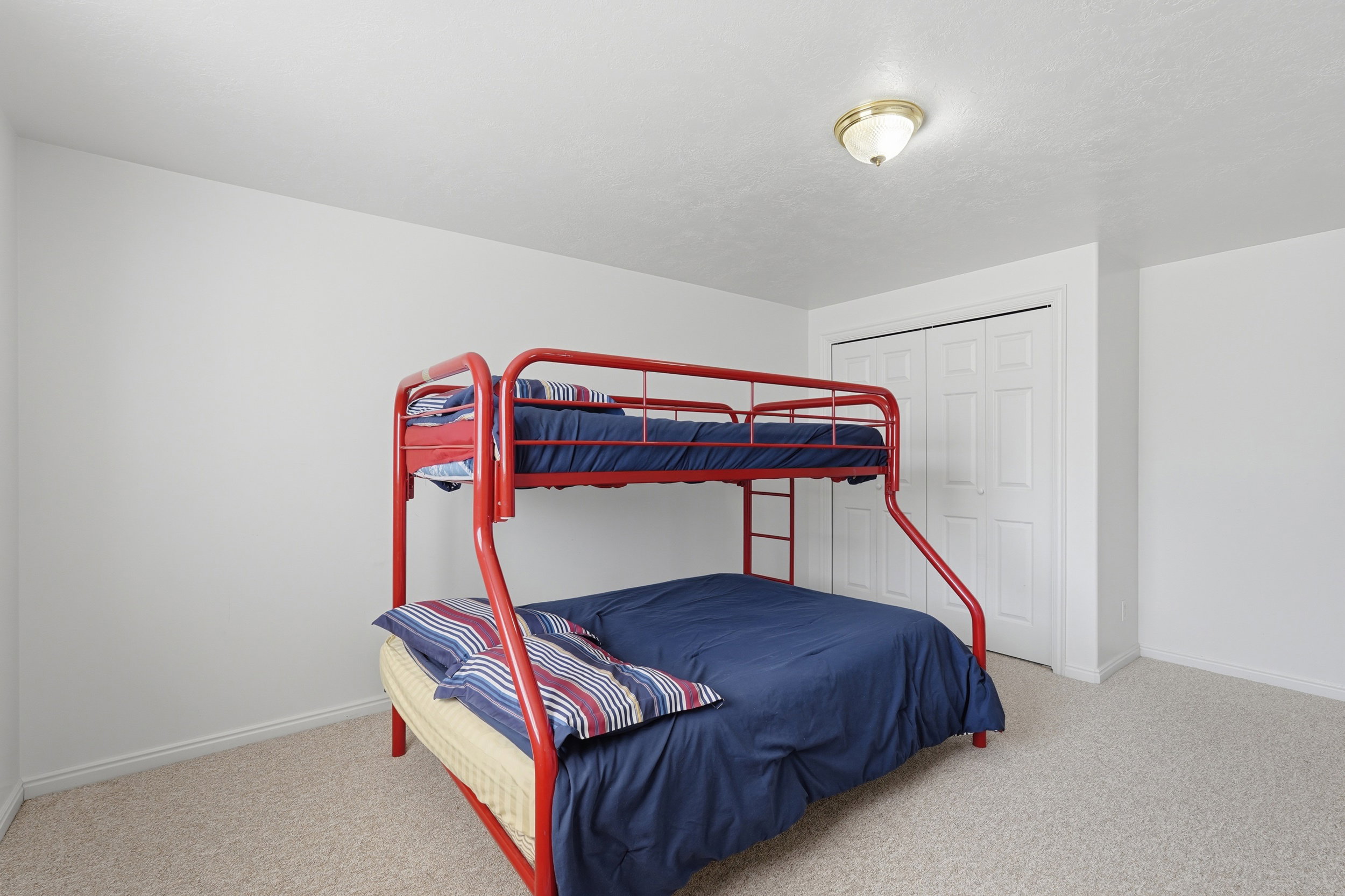 Bedroom with light colored carpet and a closet
