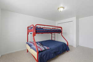Bedroom with light colored carpet and a closet