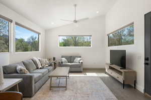 Living area featuring ceiling fan, lofted ceiling, finished concrete flooring, and recessed lighting