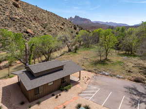 Aerial view of property and surrounding area featuring a mountainous background