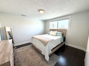 Bedroom featuring dark wood finished floors and a textured ceiling