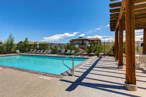 Community pool featuring a patio, a pergola, and a residential view