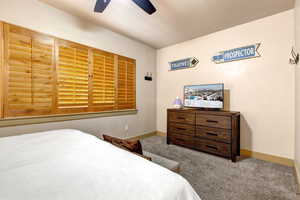 Carpeted bedroom with baseboards and a ceiling fan