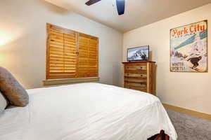 Carpeted bedroom featuring baseboards and ceiling fan