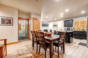 Dining room featuring wood finish floors, a fireplace, and recessed lighting