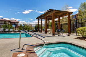 Swimming pool featuring a patio, a pergola, and a community hot tub