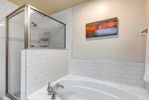 Full bathroom with a garden tub and a stall shower