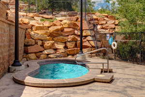 View of swimming pool with a hot tub and patio surround
