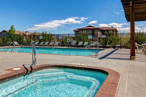 Community pool with a patio area and a hot tub