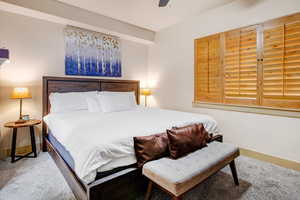 Carpeted bedroom with baseboards and a ceiling fan