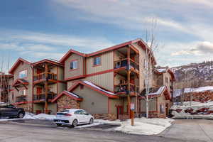Snow covered property with a view of apartment building / complex