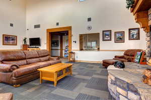 Living area with a high ceiling and dark carpet