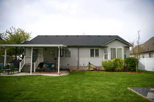 Back of house with a patio area and a shingled roof