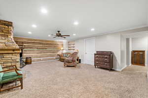 Living area with recessed lighting, a ceiling fan, carpet, ornamental molding, and an accent wall