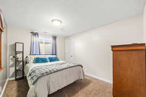 Carpeted bedroom with baseboards and a textured ceiling