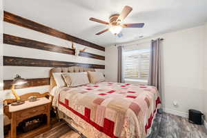Bedroom featuring a ceiling fan, wood finished floors, and a textured ceiling