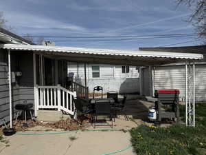 Rear view of house with a metal roof, a patio area, and outdoor dining space