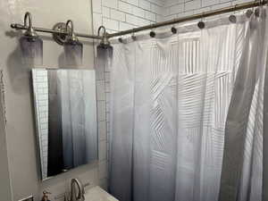 Full bath with a sink and a shower with shower curtain