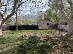 Fenced backyard featuring an outdoor fire pit and a mountain view