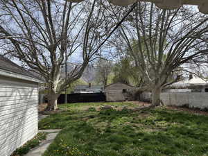Fenced backyard with an outbuilding