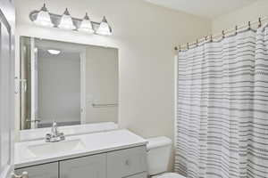 Bathroom with a shower with shower curtain and vanity