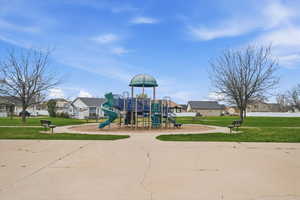 Community play area with a yard and a residential view