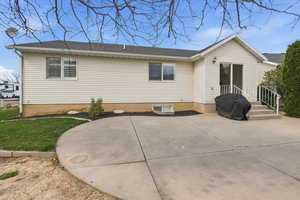 Back of house featuring a patio area and roof with shingles