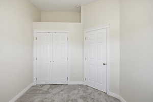 Unfurnished bedroom with light carpet and a closet