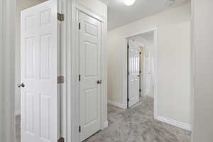 Corridor with light carpet and baseboards