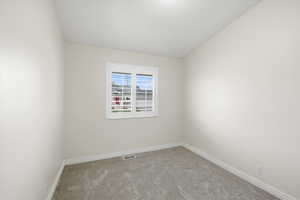 Spare room featuring light colored carpet and baseboards