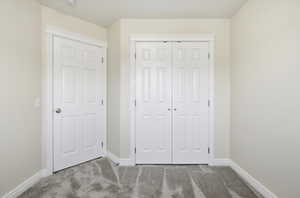 Unfurnished bedroom featuring light colored carpet and a closet