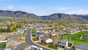 Aerial view of residential area with a mountain backdrop and property parcel outlined