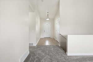 Entryway featuring baseboards and carpet flooring